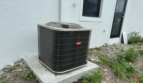New condenser on a pad beside a white wall
