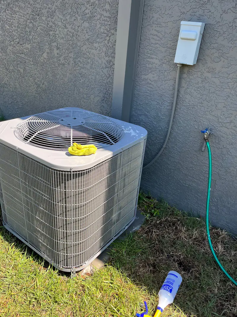 Outdoor AC unit mid-service beside a stucco wall