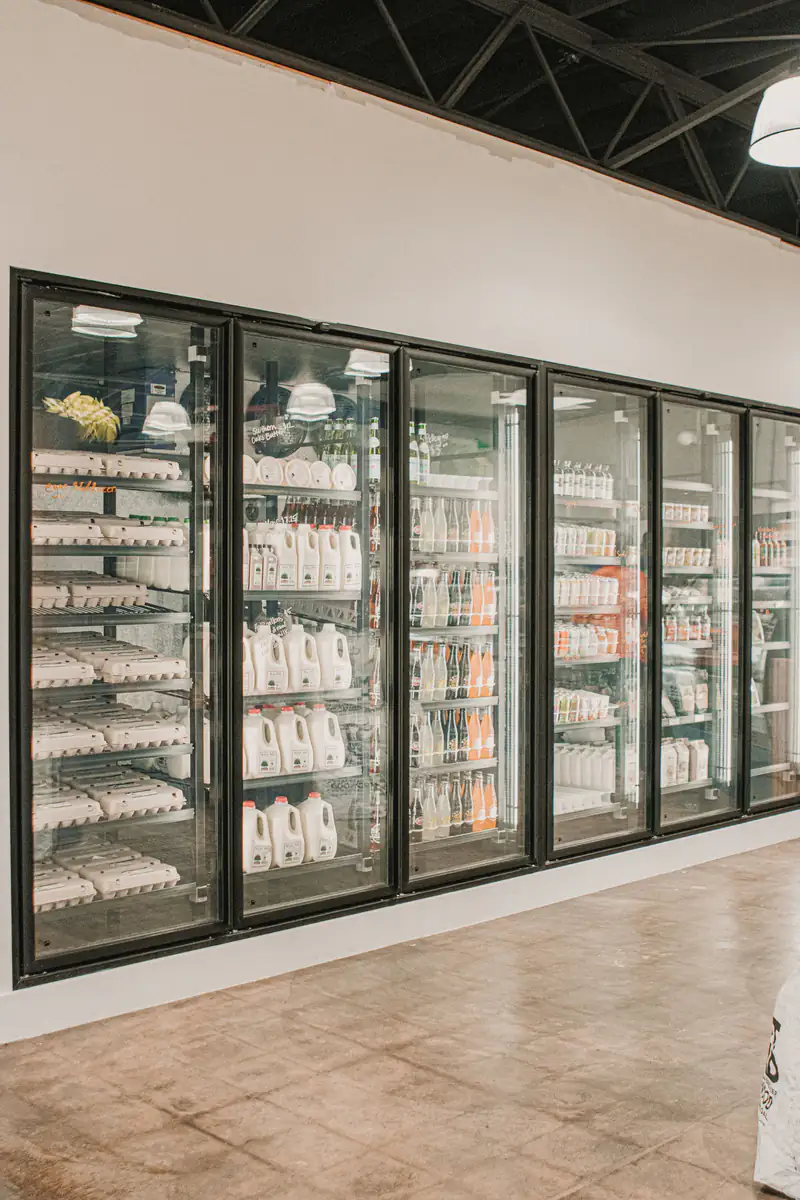 Walk-in style glass-door dairy coolers in a grocery store